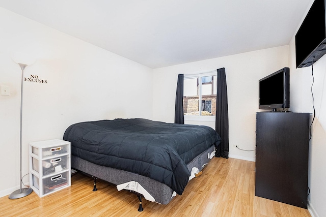 bedroom with baseboards and light wood-style flooring