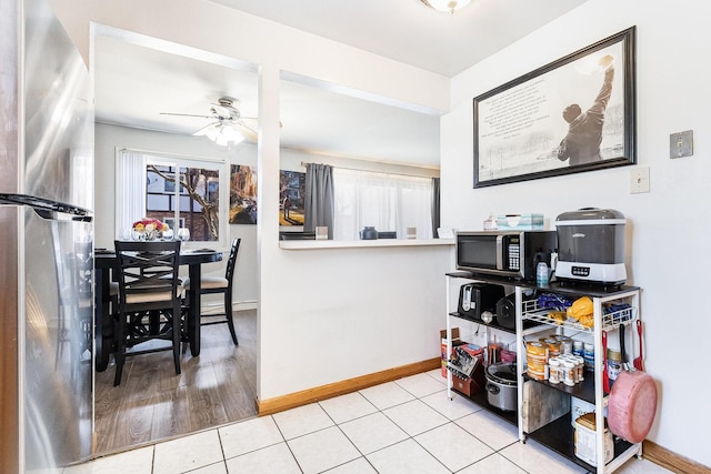 kitchen featuring stainless steel appliances, baseboards, a ceiling fan, and tile patterned flooring