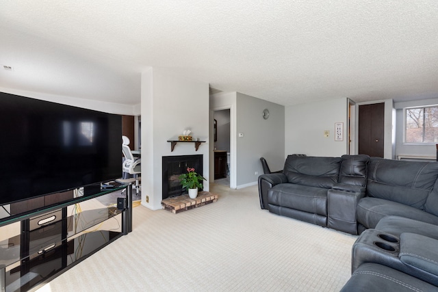 living area featuring a fireplace, a textured ceiling, baseboards, and carpet floors