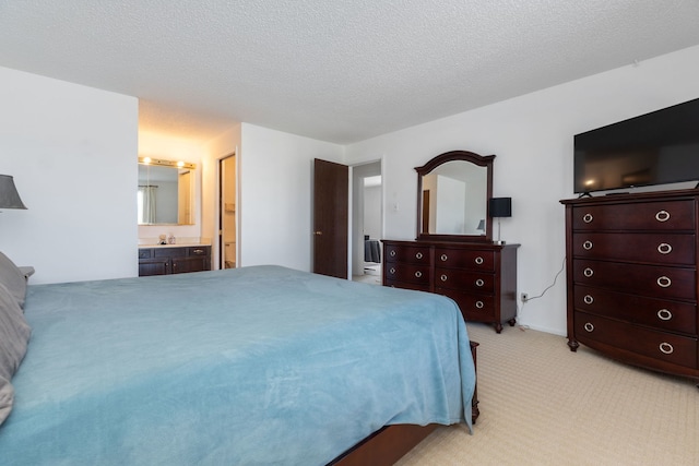 bedroom featuring a sink, connected bathroom, light colored carpet, and a textured ceiling