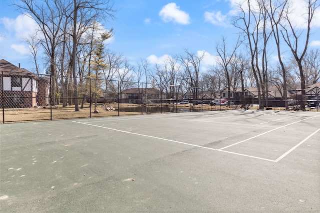 view of tennis court with a residential view, community basketball court, and fence