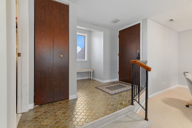 interior space featuring visible vents, baseboards, and a textured ceiling