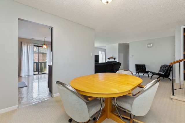 dining area with baseboards and a textured ceiling