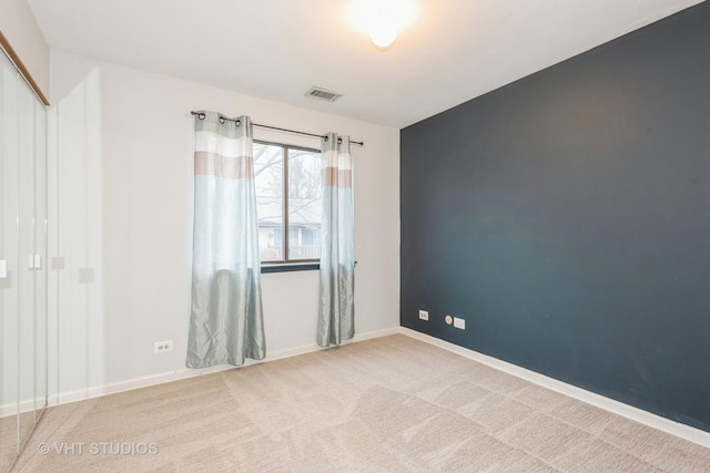 carpeted empty room with visible vents and baseboards