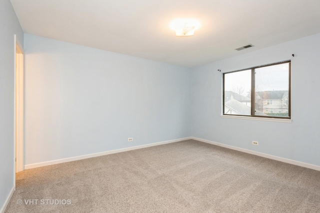 carpeted spare room with baseboards and visible vents