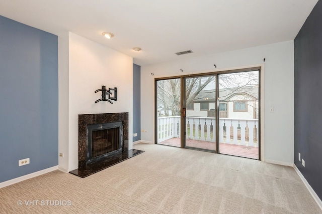 unfurnished living room with a fireplace, carpet flooring, baseboards, and visible vents