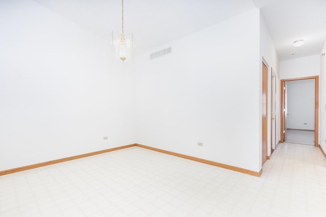 unfurnished room with visible vents, baseboards, light floors, and a notable chandelier