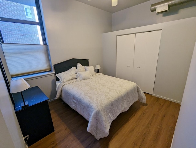 bedroom featuring baseboards, wood finished floors, a closet, and ceiling fan