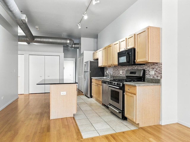 1000 E 53rd St Unit 112, Chicago, IL 60615 - kitchen with stainless steel appliances, light brown cabinetry, a kitchen island, tasteful backsplash, and a towering ceiling