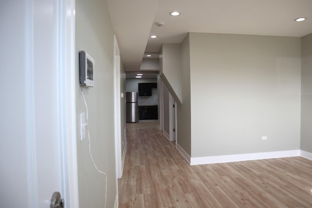 hallway with light wood finished floors, recessed lighting, and baseboards