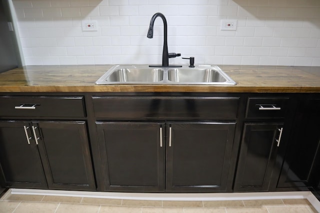 kitchen with backsplash, butcher block counters, and a sink