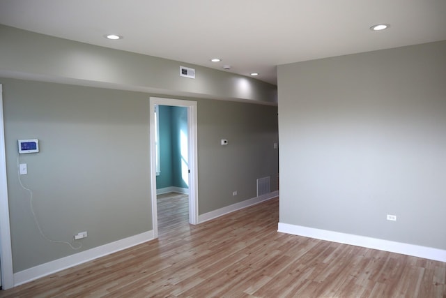 empty room with light wood finished floors, visible vents, recessed lighting, and baseboards