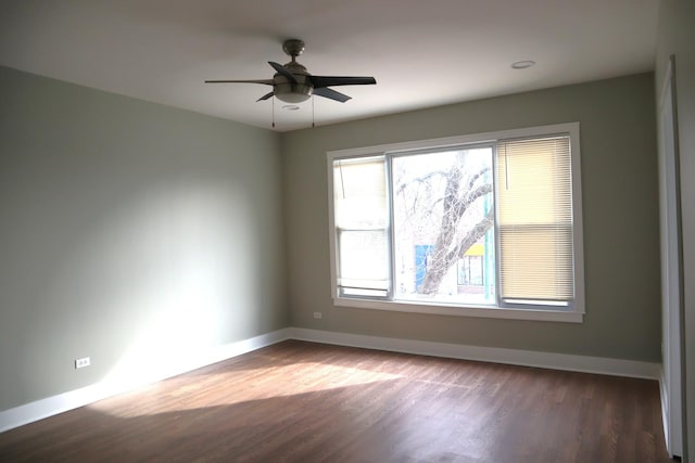 empty room featuring ceiling fan, baseboards, and wood finished floors