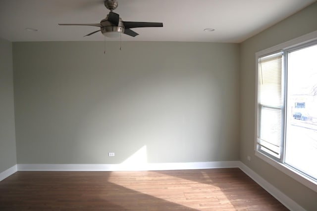 unfurnished room with a wealth of natural light, baseboards, and wood finished floors