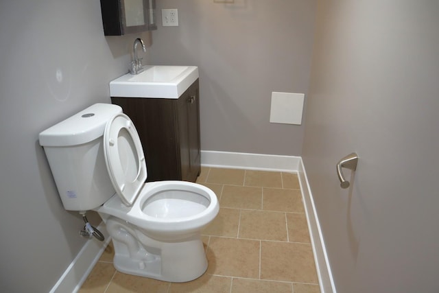 bathroom with toilet, vanity, and baseboards