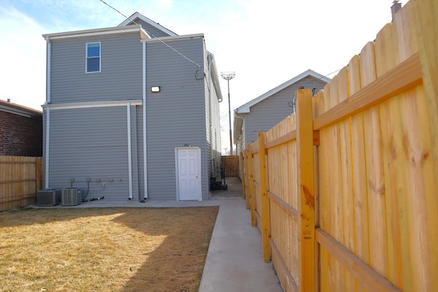 back of house with a lawn and a fenced backyard