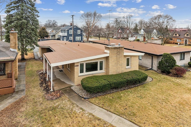 view of front of home featuring a front lawn, a residential view, and a chimney