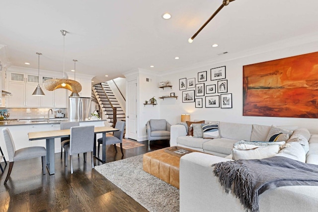 living room with ornamental molding, recessed lighting, stairs, and dark wood finished floors