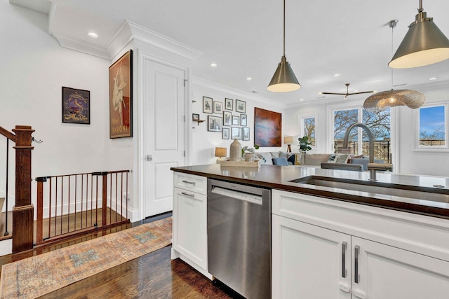 kitchen with dark wood-style floors, a sink, pendant lighting, dark countertops, and dishwasher