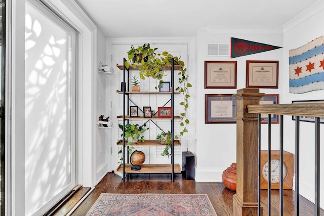 entryway with visible vents, wood finished floors, and crown molding