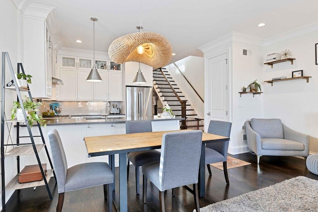 dining area with stairway, dark wood-style flooring, baseboards, visible vents, and crown molding