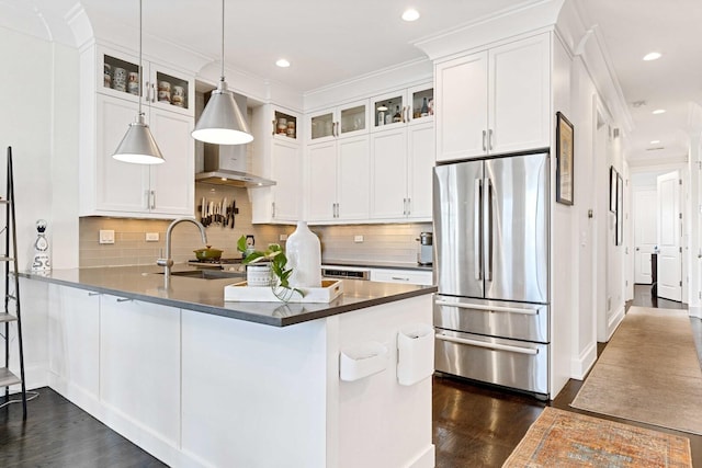 kitchen with glass insert cabinets, a sink, dark wood-style floors, freestanding refrigerator, and a peninsula