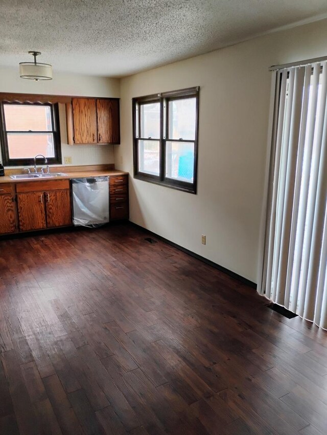 unfurnished living room featuring dark wood-style flooring and a textured ceiling