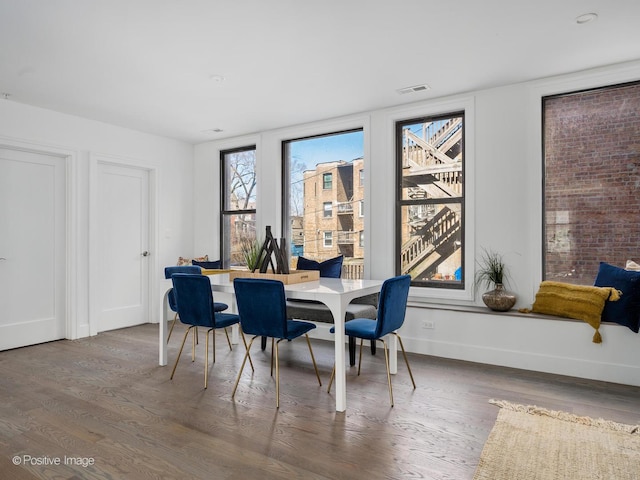 dining space featuring visible vents, baseboards, and wood finished floors