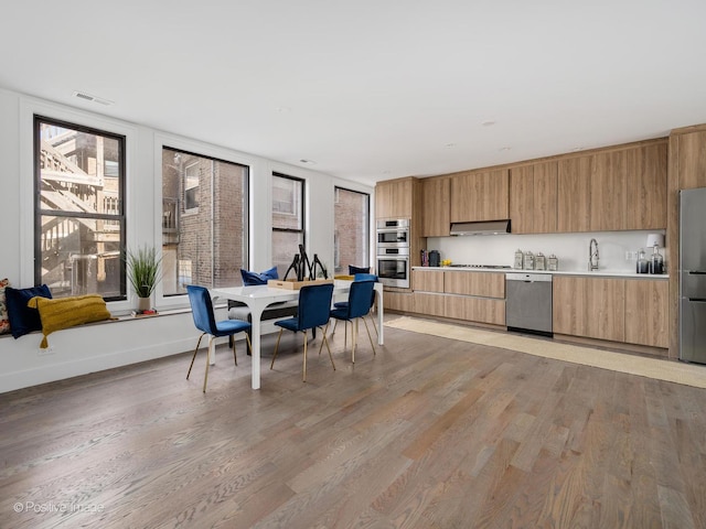 dining room with light wood-style floors and visible vents