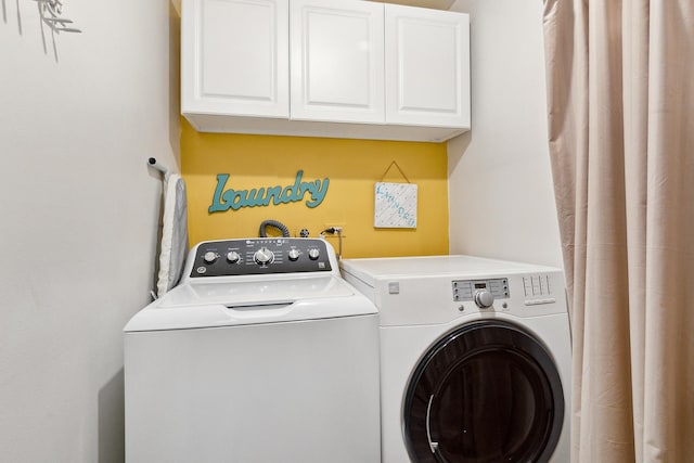 clothes washing area with cabinet space and separate washer and dryer