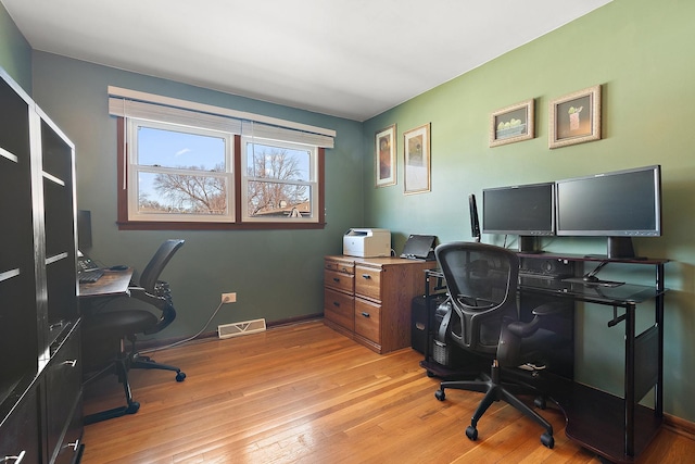 office space with visible vents, light wood-type flooring, and baseboards