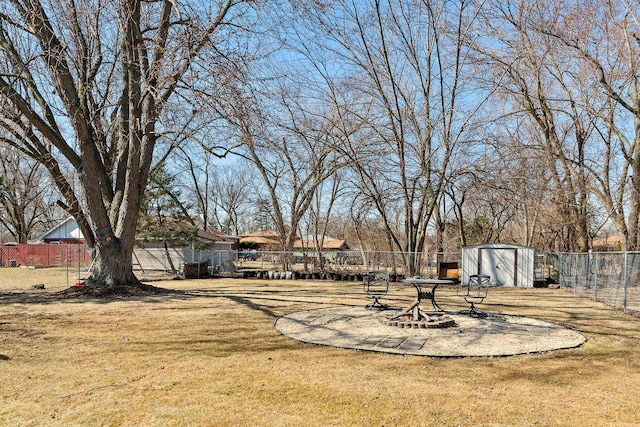 view of yard featuring a patio area, a shed, an outdoor structure, and fence