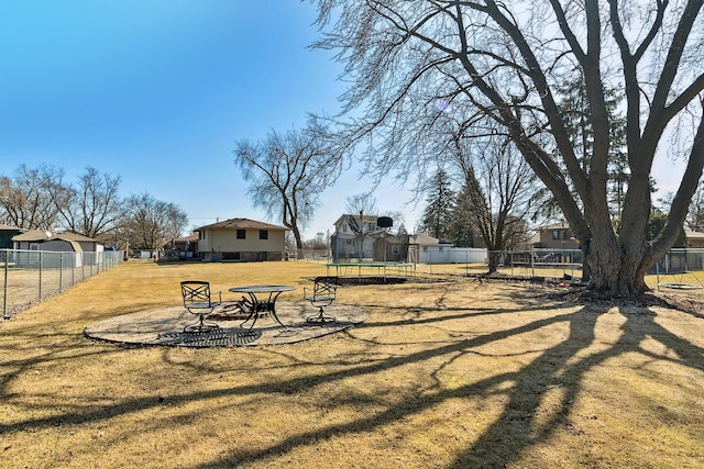 view of yard featuring a trampoline and a fenced backyard