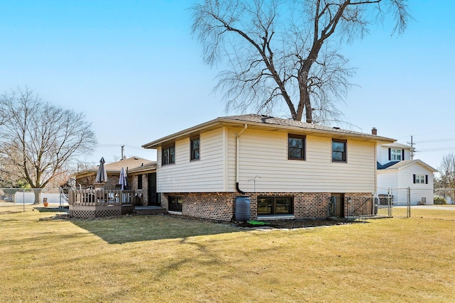 back of property featuring a lawn, fence, and a wooden deck