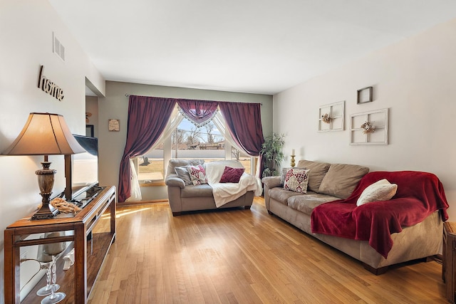 living area with visible vents and hardwood / wood-style floors