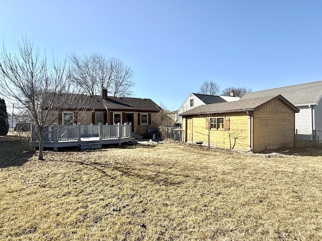 back of house with a deck and an outdoor structure