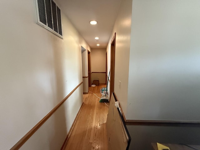 hall with an upstairs landing, recessed lighting, and light wood-type flooring