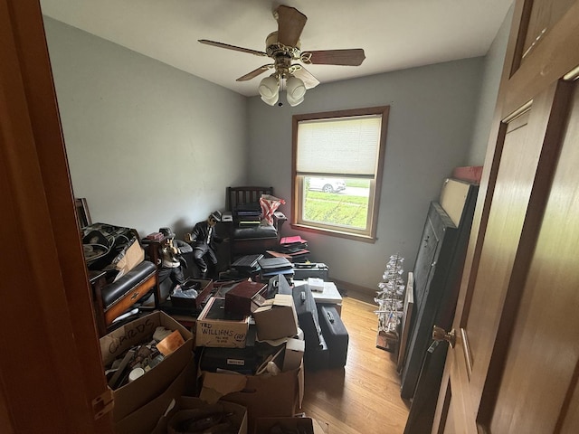 miscellaneous room featuring light wood-style flooring, ceiling fan, and an office area