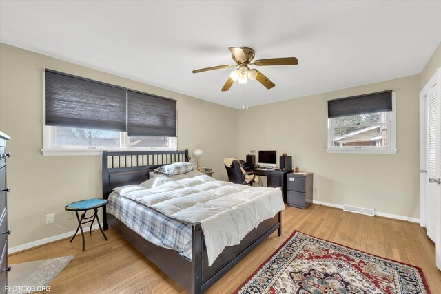 bedroom with visible vents, multiple windows, baseboards, and wood finished floors