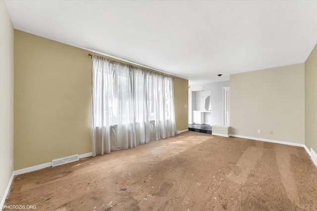 unfurnished living room with visible vents and baseboards