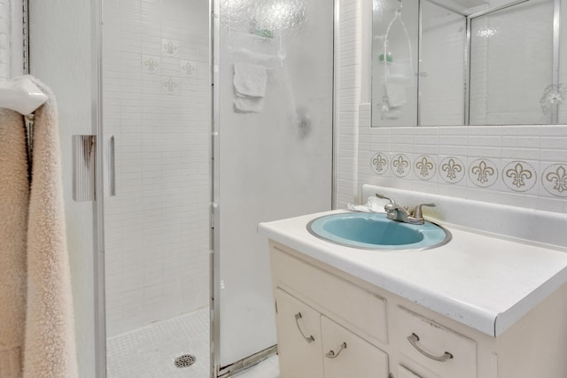 full bathroom with tasteful backsplash, vanity, and a shower stall