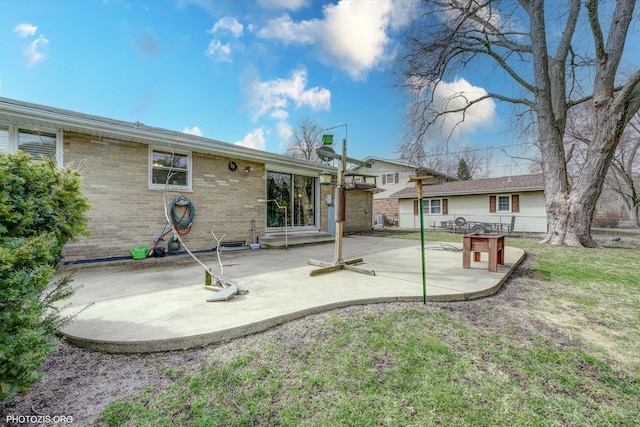 back of house featuring brick siding, a chimney, and a patio area