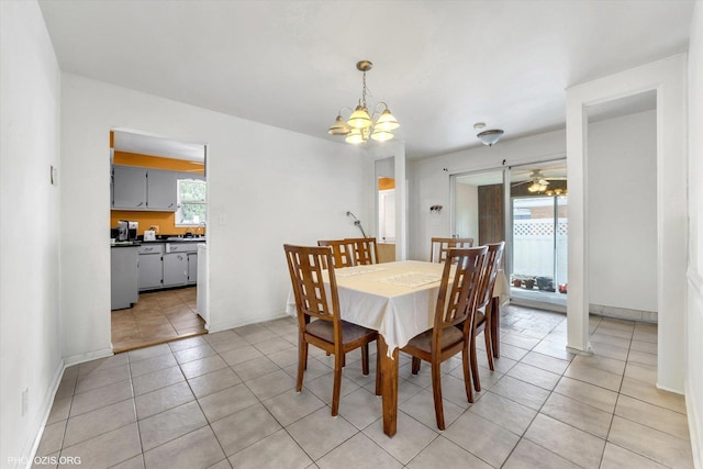 dining space featuring light tile patterned floors, baseboards, and a chandelier