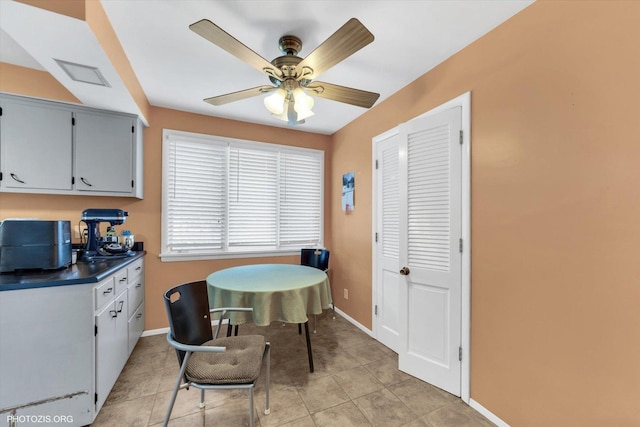 dining area featuring light tile patterned floors, baseboards, and ceiling fan