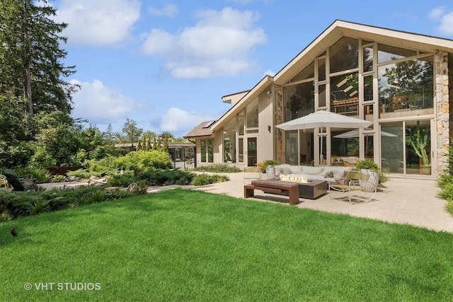 back of property with a patio, an outdoor living space with a fire pit, a lawn, and a sunroom