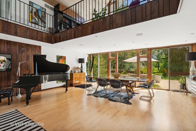 interior space featuring expansive windows, wood finished floors, and a towering ceiling