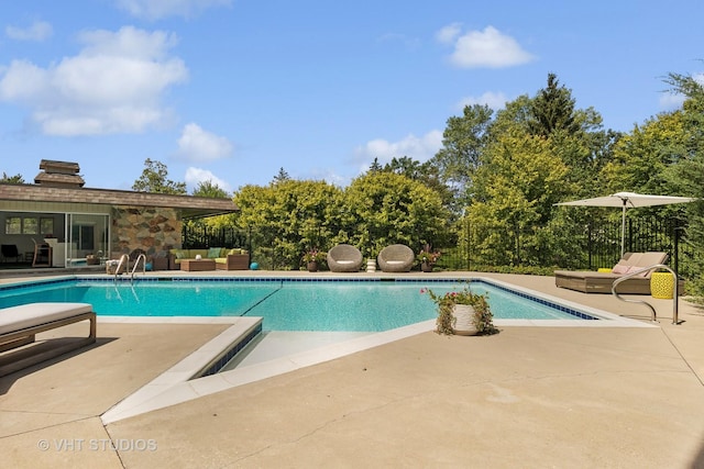 view of pool with a fenced in pool, outdoor lounge area, and a patio area