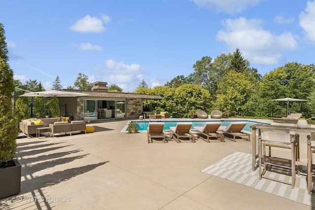 outdoor pool with an outdoor hangout area and a patio