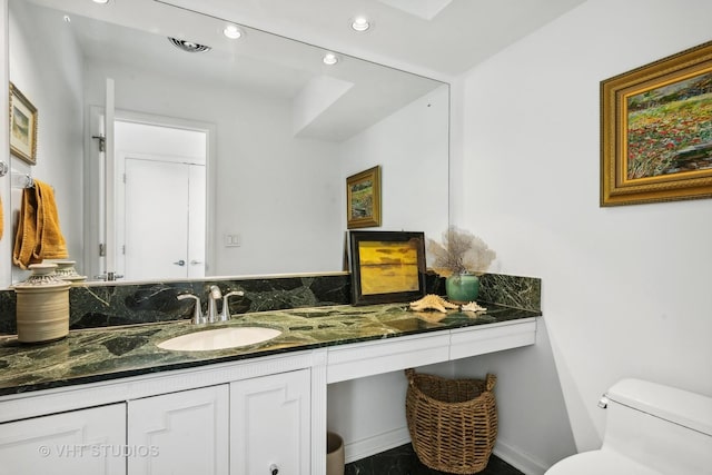 bathroom featuring toilet, baseboards, recessed lighting, and vanity