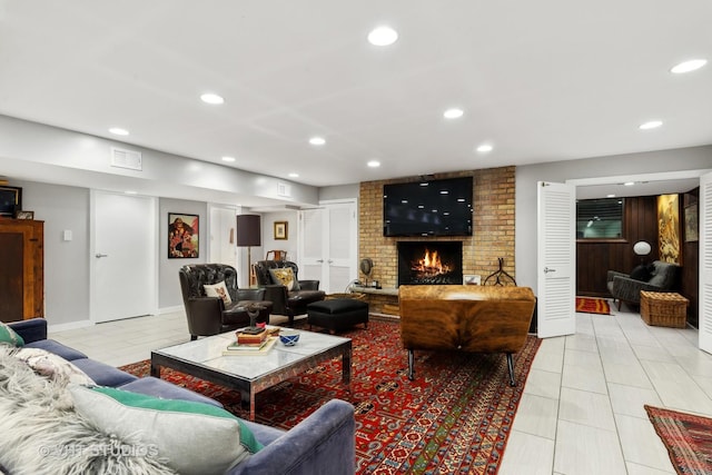living room with a fireplace, recessed lighting, and light tile patterned flooring